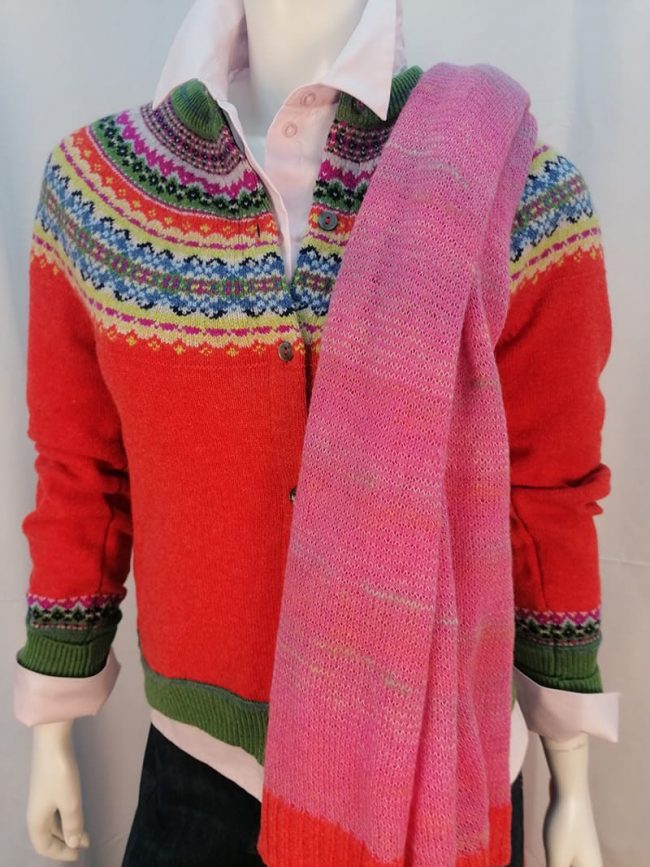Rote Wolljacke mit buntem Kragen und rosa Schal